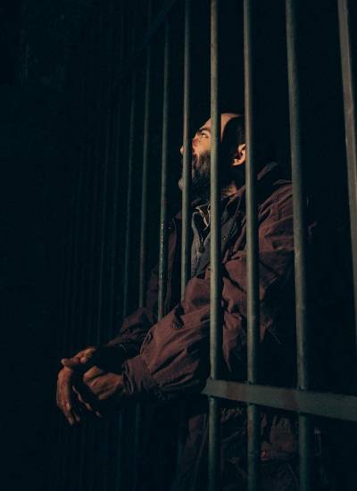 Fotografía referencial de un hombre detenido en una celda oscura.
