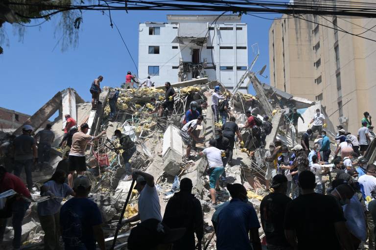 $!Personas buscan sobrevivientes entre los escombros de un edificio colapsado tras el terremoto en Cali, Colombia, el 10 de agosto de 2026. El fuerte sismo, de magnitud 7,4, dejó daños y edificios colapsados en varias ciudades.