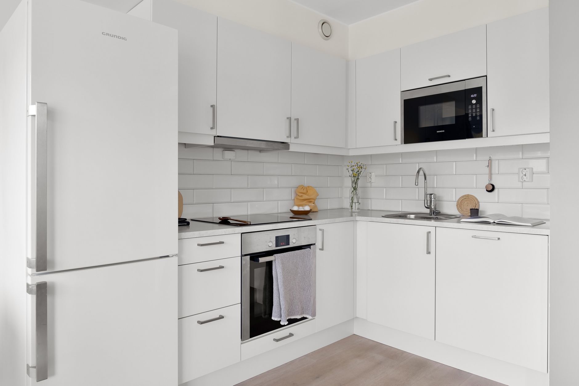 Cozinha branca elegante com eletrodomésticos modernos e decoração minimalista, perfeita para elegância.